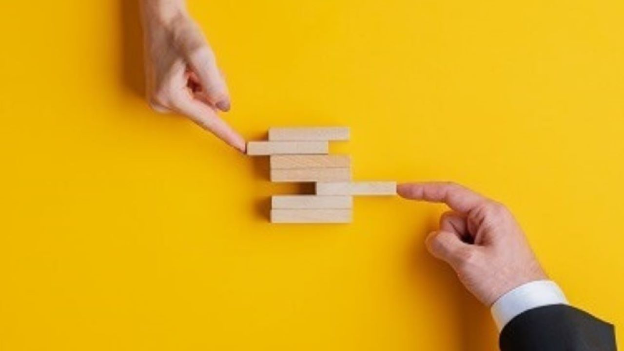 Two hands pushing blocks together to make a new box